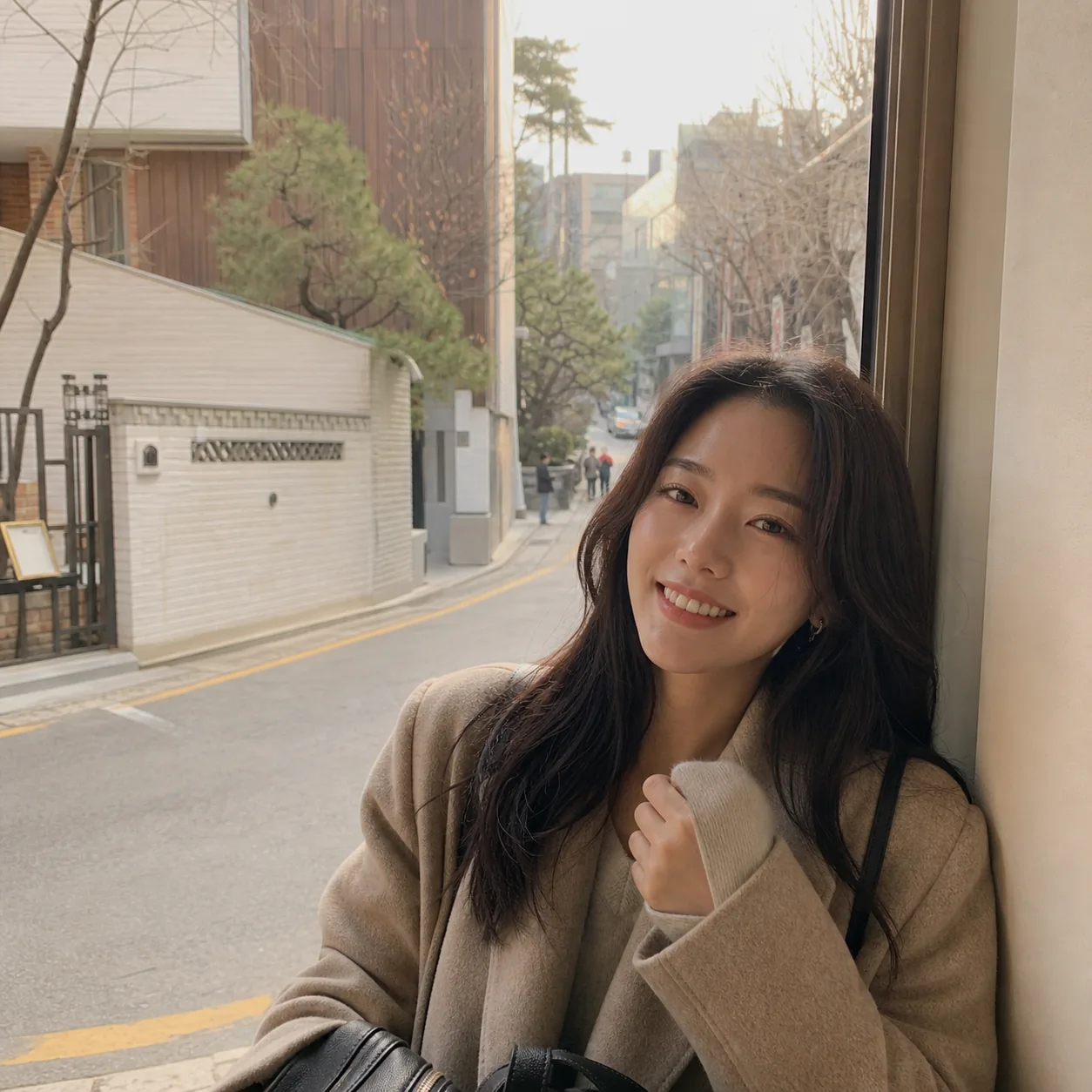 A woman smiling on a quiet Seoul side street